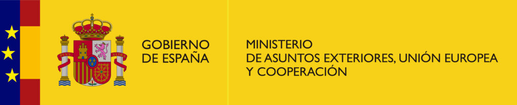 Logotipo do Governo da Espanha sobre fundo amarelo. À esquerda, uma faixa vertical azul com quatro estrelas amarelas e, ao lado, o brasão de armas da Espanha. À direita do brasão, o texto em preto “Gobierno de España” e, ao lado, “Ministerio de Asuntos Exteriores, Unión Europea y Cooperación”.